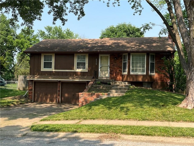 8425 N Tracy Ave, Kansas City, MO 64155 - view of front of house featuring a garage, concrete driveway, brick siding, and board and batten siding