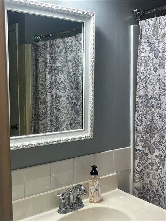 8425 N Tracy Ave, Kansas City, MO 64155 - bathroom featuring vanity, tasteful backsplash, and curtained shower