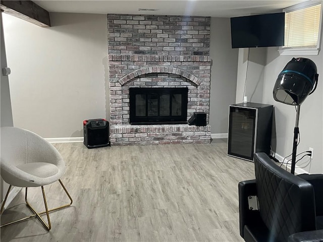 8425 N Tracy Ave, Kansas City, MO 64155 - living area with wood finished floors, a brick fireplace, and baseboards