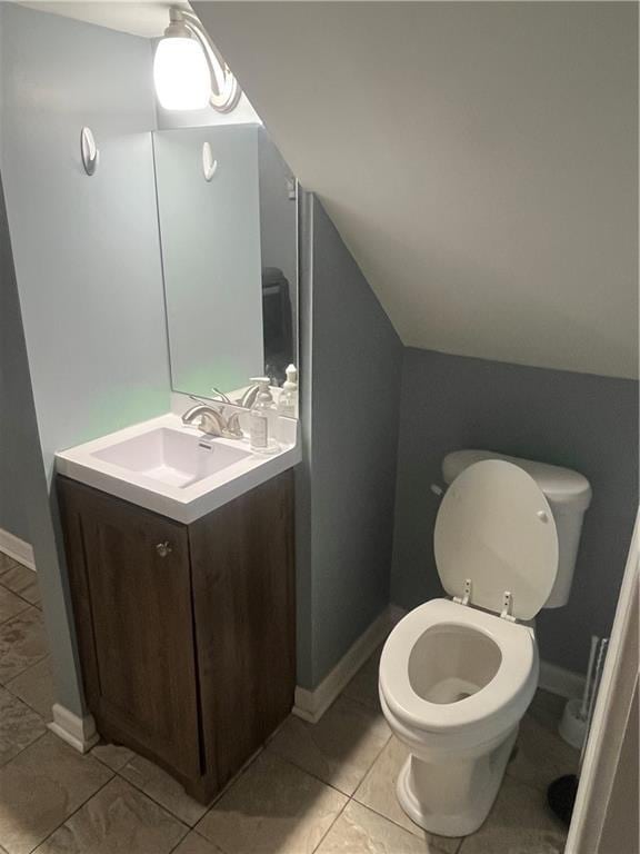 8425 N Tracy Ave, Kansas City, MO 64155 - half bathroom with vanity, toilet, baseboards, and vaulted ceiling