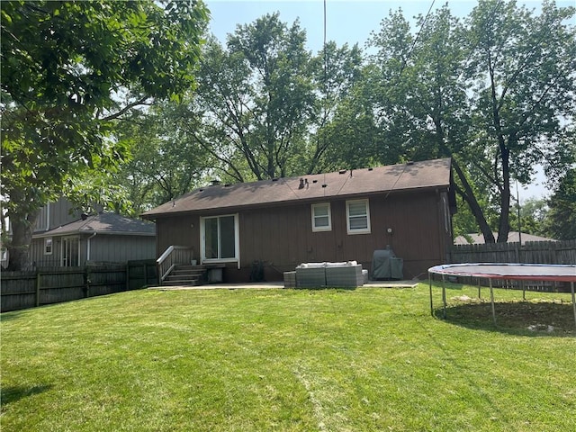 8425 N Tracy Ave, Kansas City, MO 64155 - back of house with a trampoline, entry steps, a patio, and an outdoor hangout area