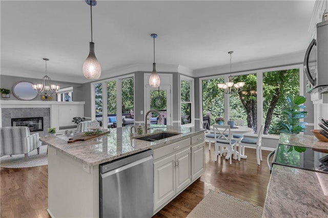 7208 Oakview St, Shawnee, KS 66216 - kitchen with appliances with stainless steel finishes, a chandelier, a sink, a tiled fireplace, and light stone countertops