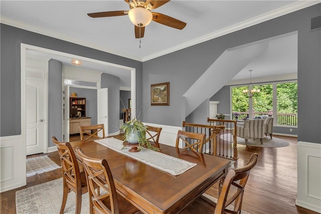 7208 Oakview St, Shawnee, KS 66216 - dining room with wood finished floors, a wainscoted wall, a ceiling fan, and ornamental molding