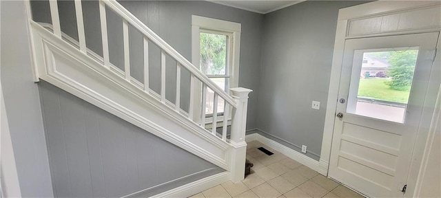403 S St, Iola, KS 66749 - entrance foyer with light tile patterned floors, stairway, and healthy amount of natural light