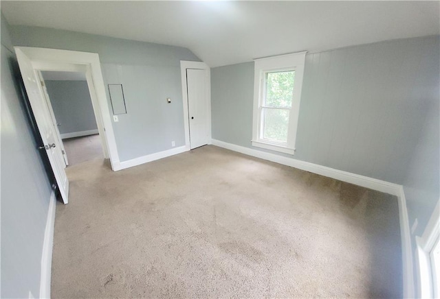 403 S St, Iola, KS 66749 - unfurnished bedroom featuring vaulted ceiling, baseboards, and carpet floors