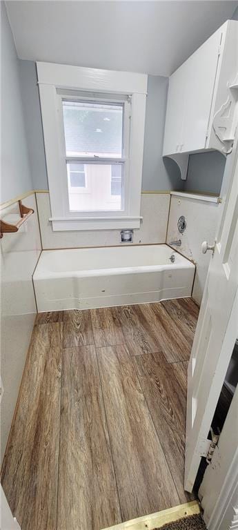 403 S St, Iola, KS 66749 - bathroom featuring a garden tub and wood finished floors