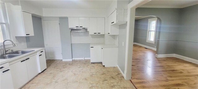 403 S St, Iola, KS 66749 - kitchen with a sink, arched walkways, light countertops, white cabinetry, and crown molding