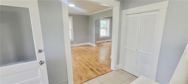 403 S St, Iola, KS 66749 - hallway with crown molding, arched walkways, baseboards, and light wood-style floors