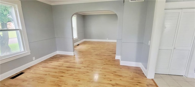 403 S St, Iola, KS 66749 - empty room with arched walkways, ornamental molding, light wood-style flooring, and baseboards
