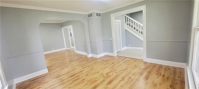 403 S St, Iola, KS 66749 - empty room with arched walkways, ornamental molding, wood finished floors, baseboards, and stairway
