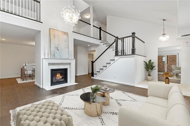 1810 S 98th St, Edwardsville, KS 66111 - living room with a towering ceiling, stairs, a fireplace with flush hearth, wood finished floors, and a chandelier