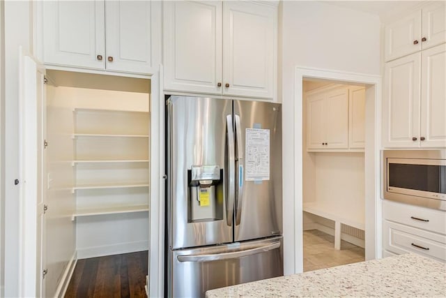 22900 S Ridgeview Dr, Peculiar, MO 64078 - kitchen featuring stainless steel appliances, white cabinets, baseboards, and light stone counters