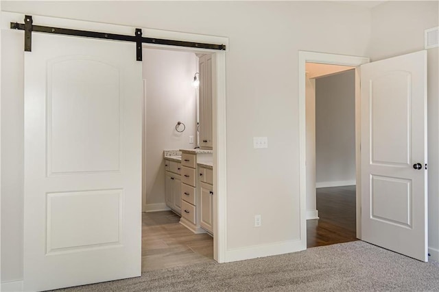 22900 S Ridgeview Dr, Peculiar, MO 64078 - unfurnished bedroom with light carpet, baseboards, and a barn door