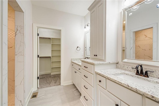 22900 S Ridgeview Dr, Peculiar, MO 64078 - bathroom with two vanities, a shower, a spacious closet, and baseboards
