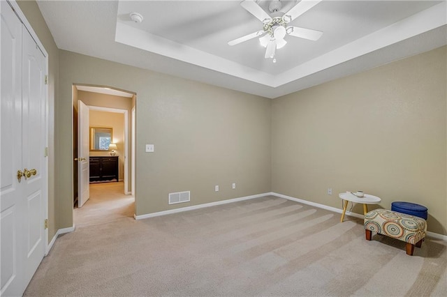 3222 SW Shadow Brook Dr, Blue Springs, MO 64015 - unfurnished bedroom with light carpet, a tray ceiling, arched walkways, and a ceiling fan