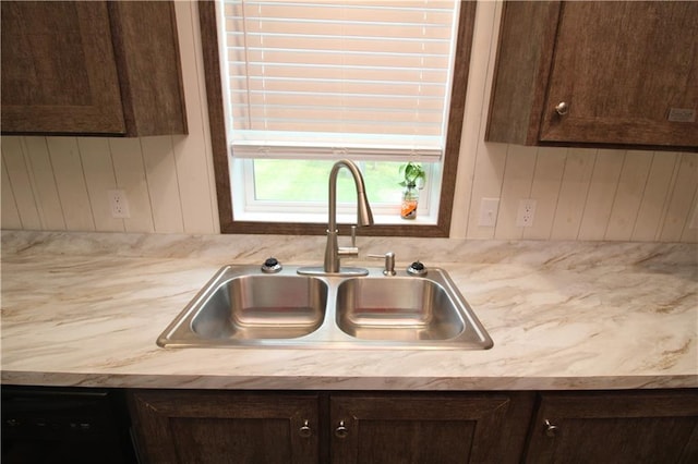 17922 County Road 361, Savannah, MO 64485 - kitchen featuring a sink, dark brown cabinets, light countertops, black dishwasher, and wood walls