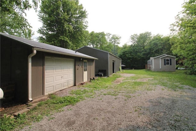 17922 County Road 361, Savannah, MO 64485 - view of yard with a garage, dirt driveway, view of wooded area, and an outdoor structure