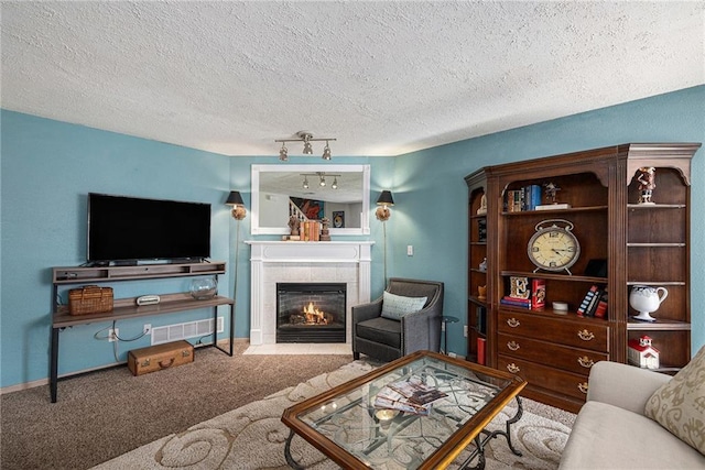 1404 SE Lexington Ave, Lees Summit, MO 64081 - carpeted living area featuring a textured ceiling, a tile fireplace, baseboards, and track lighting