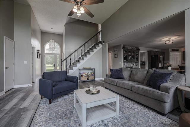 11702 E 246th St, Peculiar, MO 64078 - living room with a textured ceiling, wood finished floors, stairway, a ceiling fan, and a chandelier