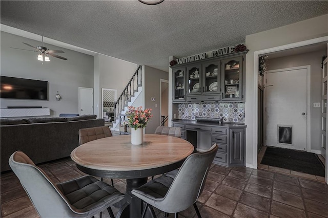 11702 E 246th St, Peculiar, MO 64078 - dining space featuring stairs, a ceiling fan, and a textured ceiling