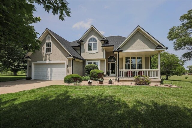 11702 E 246th St, Peculiar, MO 64078 - view of front of property with a porch, a front yard, concrete driveway, stucco siding, and a shingled roof