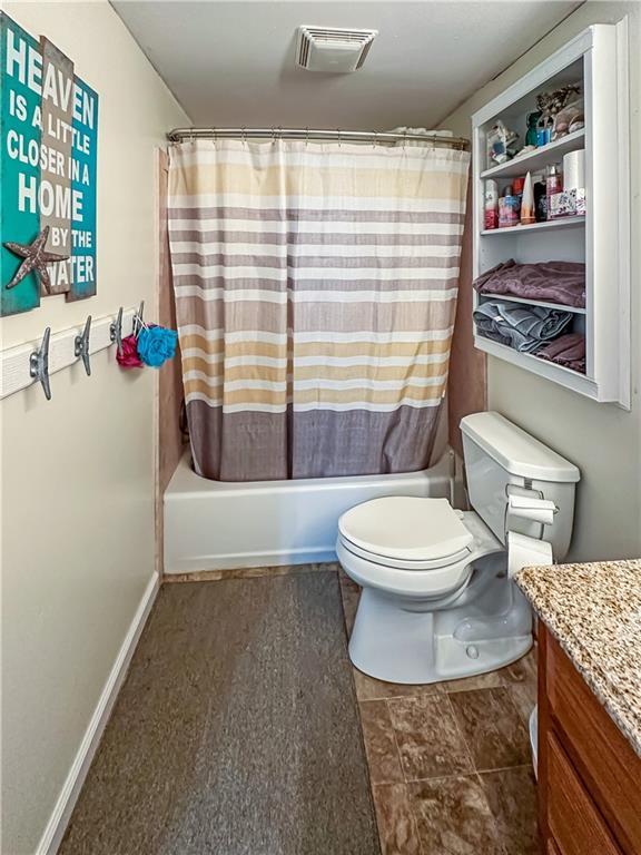 15157 Bass Cove Rd, Gravois Mills, MO 65037 - full bath with vanity, toilet, and shower / bath combo with shower curtain
