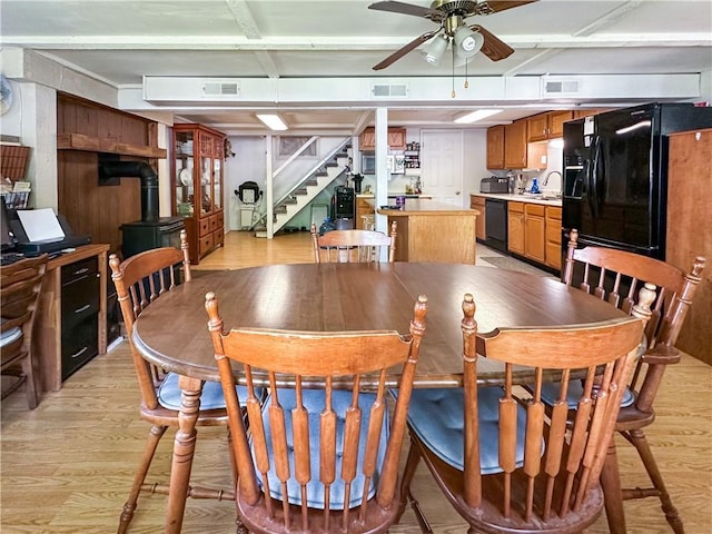 15157 Bass Cove Rd, Gravois Mills, MO 65037 - dining space featuring a wood stove, ceiling fan, light wood-style floors, and stairway