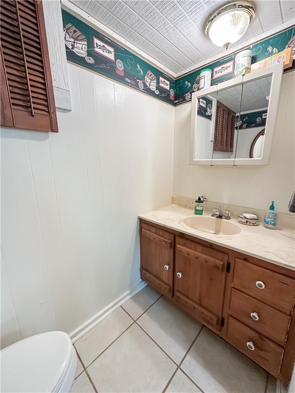 15157 Bass Cove Rd, Gravois Mills, MO 65037 - half bathroom with vanity, toilet, and tile patterned flooring