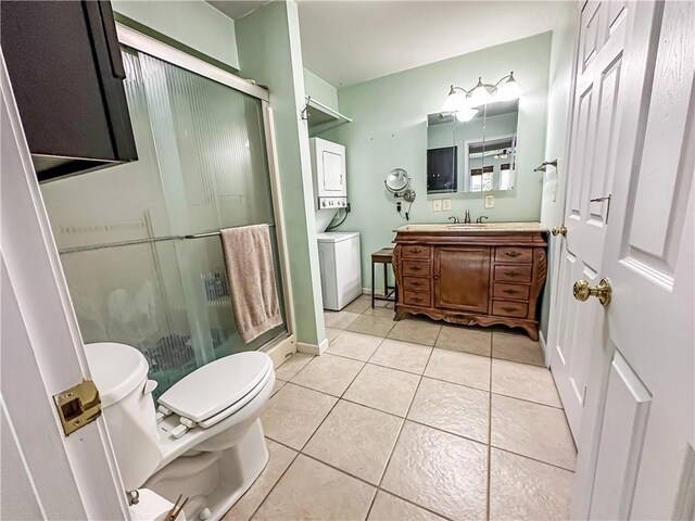 15157 Bass Cove Rd, Gravois Mills, MO 65037 - full bathroom with stacked washer and clothes dryer, toilet, vanity, a stall shower, and tile patterned flooring