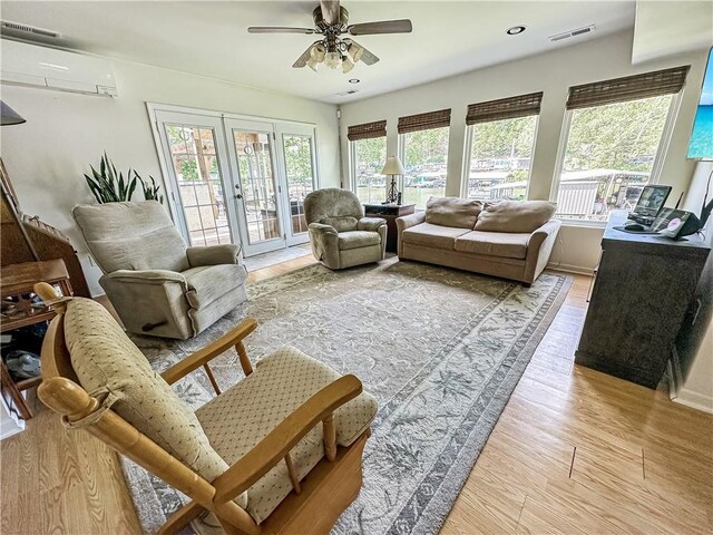 15157 Bass Cove Rd, Gravois Mills, MO 65037 - living room featuring a wall unit AC, light wood-type flooring, ceiling fan, french doors, and recessed lighting