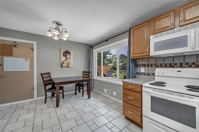 7316 E 109th St, Kansas City, MO 64134 - kitchen featuring white appliances, a chandelier, baseboards, tasteful backsplash, and light countertops