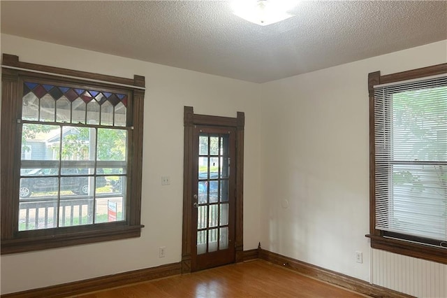 903 Osage St, Leavenworth, KS 66048 - spare room with wood finished floors, baseboards, and a textured ceiling