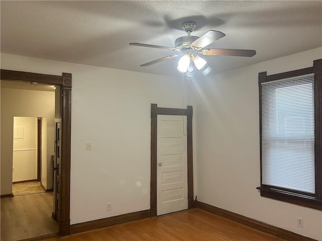 903 Osage St, Leavenworth, KS 66048 - unfurnished bedroom with light wood-style flooring, a textured ceiling, baseboards, and ceiling fan
