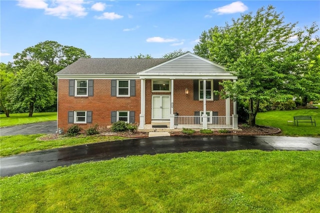 8726 W 104th St, Overland Park, KS 66212 - bi-level home with covered porch, a front lawn, and brick siding
