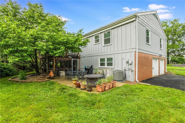 8726 W 104th St, Overland Park, KS 66212 - back of house featuring board and batten siding, cooling unit, asphalt driveway, a lawn, and a garage