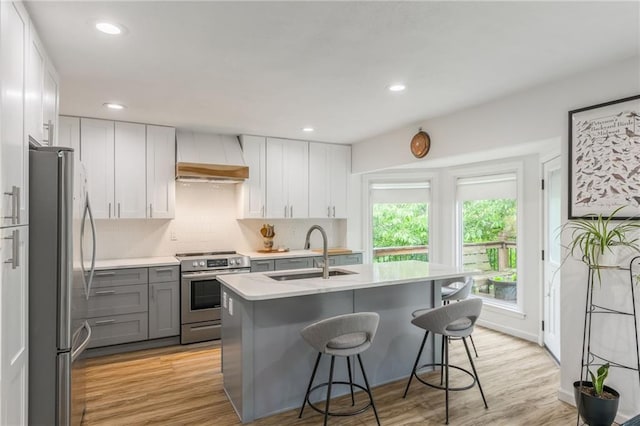 8726 W 104th St, Overland Park, KS 66212 - kitchen with stainless steel appliances, a sink, custom range hood, gray cabinets, and light countertops