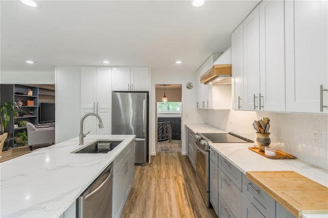 8726 W 104th St, Overland Park, KS 66212 - kitchen with stainless steel appliances, a sink, premium range hood, light wood-type flooring, and recessed lighting