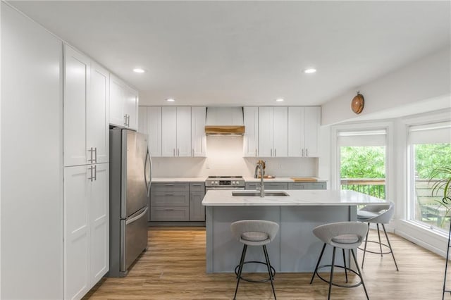 8726 W 104th St, Overland Park, KS 66212 - kitchen featuring appliances with stainless steel finishes, a sink, a breakfast bar area, white cabinets, and light countertops