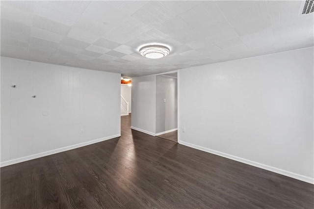 7 NW 88th St, Kansas City, MO 64155 - unfurnished room featuring dark wood-type flooring, baseboards, and stairway