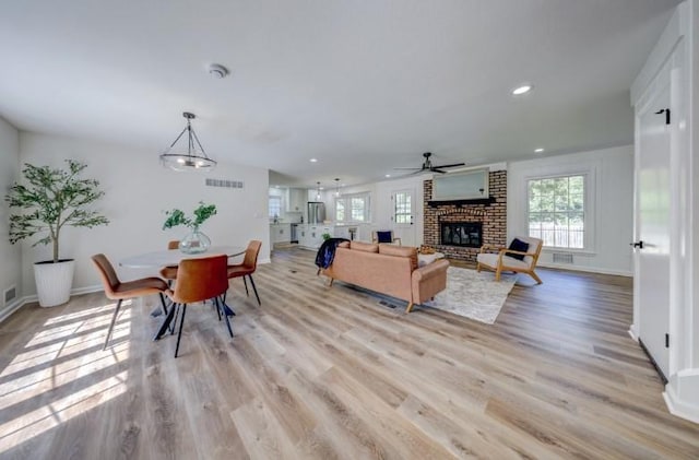 10409 Russell St, Overland Park, KS 66212 - living room with healthy amount of natural light, ceiling fan, recessed lighting, a brick fireplace, and light wood-style flooring