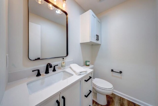 10409 Russell St, Overland Park, KS 66212 - bathroom featuring vanity, toilet, wood finished floors, and baseboards