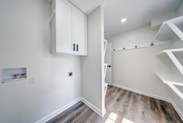 10409 Russell St, Overland Park, KS 66212 - laundry room with electric dryer hookup, hookup for a washing machine, wood finished floors, baseboards, and cabinet space