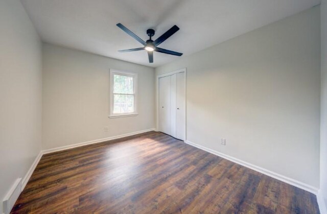 10409 Russell St, Overland Park, KS 66212 - unfurnished bedroom featuring baseboards, dark wood-type flooring, and a closet