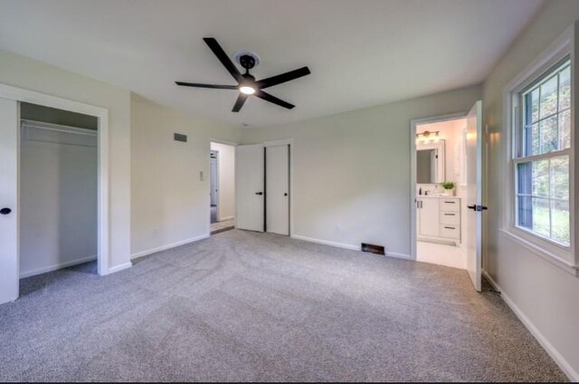 10409 Russell St, Overland Park, KS 66212 - unfurnished bedroom featuring two closets, carpet floors, and baseboards