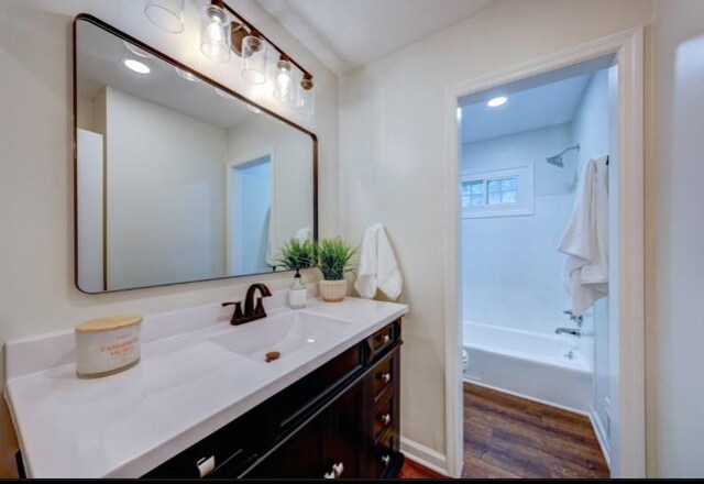 10409 Russell St, Overland Park, KS 66212 - bathroom with vanity, wood finished floors, toilet, bathtub / shower combination, and recessed lighting