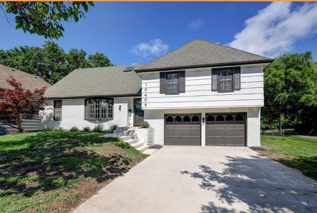 10409 Russell St, Overland Park, KS 66212 - split level home with an attached garage, brick siding, concrete driveway, and roof with shingles