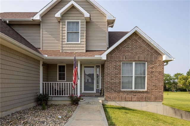 130 SW 95th Rd, Warrensburg, MO 64093 - view of front of house featuring covered porch, roof with shingles, brick siding, and a front yard