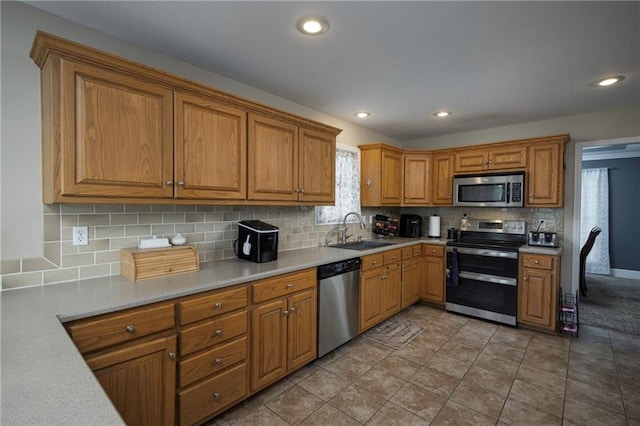 130 SW 95th Rd, Warrensburg, MO 64093 - kitchen with appliances with stainless steel finishes, a sink, brown cabinets, tasteful backsplash, and light countertops