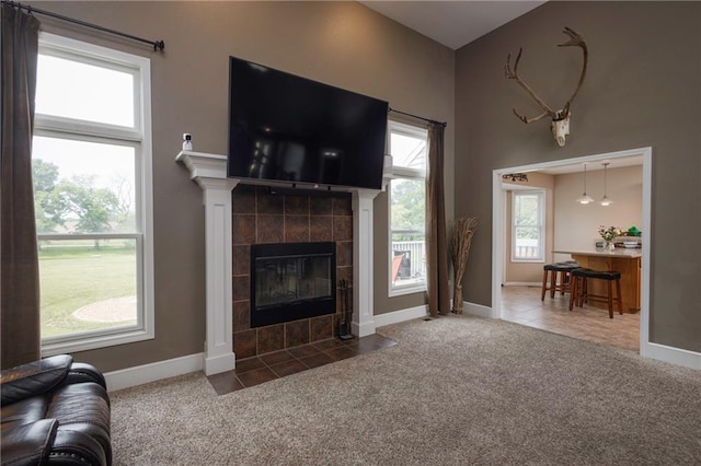 130 SW 95th Rd, Warrensburg, MO 64093 - tiled living room with carpet, baseboards, and a tiled fireplace