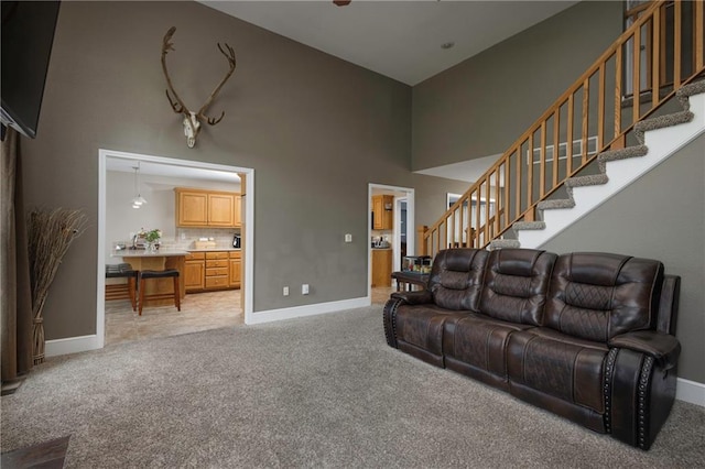 130 SW 95th Rd, Warrensburg, MO 64093 - living room with light colored carpet, a towering ceiling, stairs, and baseboards